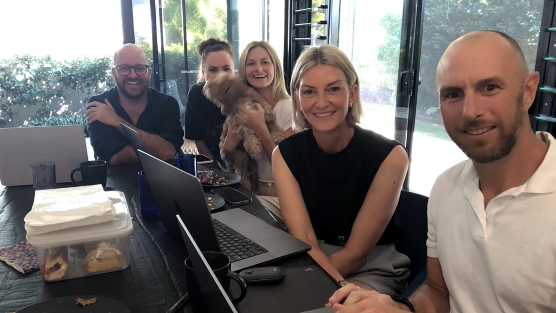 Group business meeting about franchising with a dog sitting at the table.